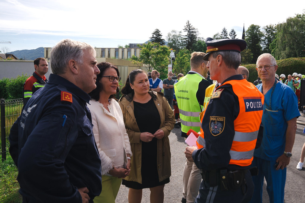 LR Daniela Gutschi und SALK-Geschäftsführerin Silvia Lechner im Gespräch mit Manfred Lindenthaler (Stadtpolizeikommandant) bei der Übung am neuen Hubschrauberlandeplatz der Christian-Doppler-Klinik.